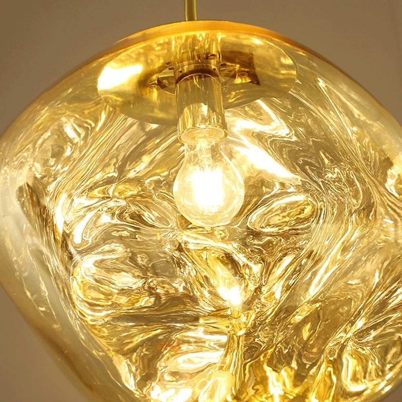 Golden pendant light detail with illuminated bulb