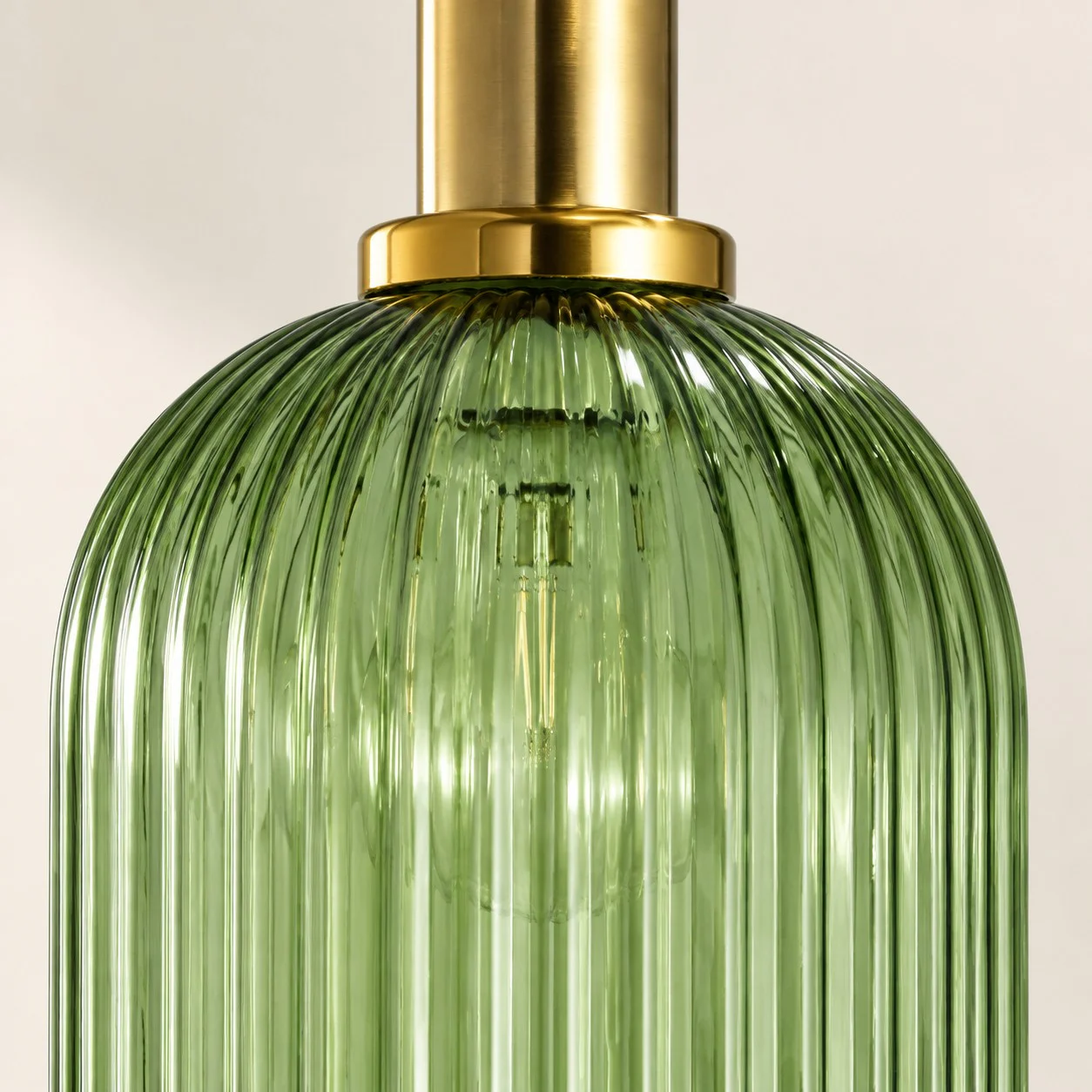 Close-up of green ribbed glass and brass-tone collar