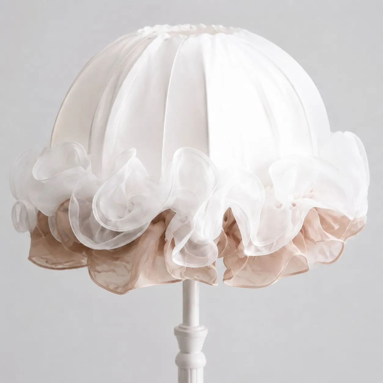Close-up of layered white and blush ruffles on the gathered fabric lampshade